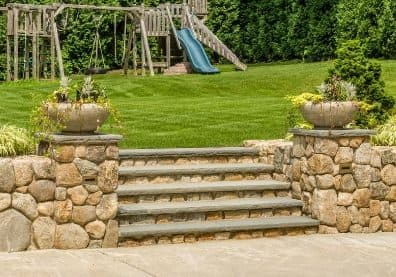 stone steps landscape design with wooden playground