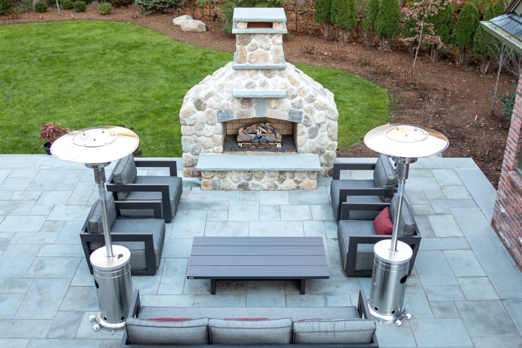 Whitewashed stone fireplace adds the perfect accent to your backyard landscape design